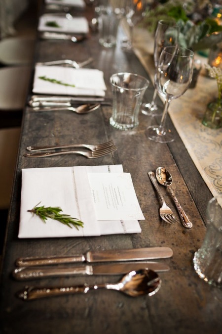 Srebrne sztućce, białe szkło i krochmalone serwetki na stole