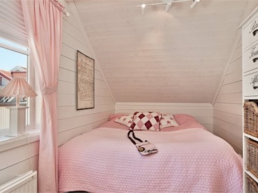 Ta biało – różowa sypialnia to urocze pomieszczenie, które wprost zaprasza do odpoczynku. Różowa kapa, zasłonka i lampa...