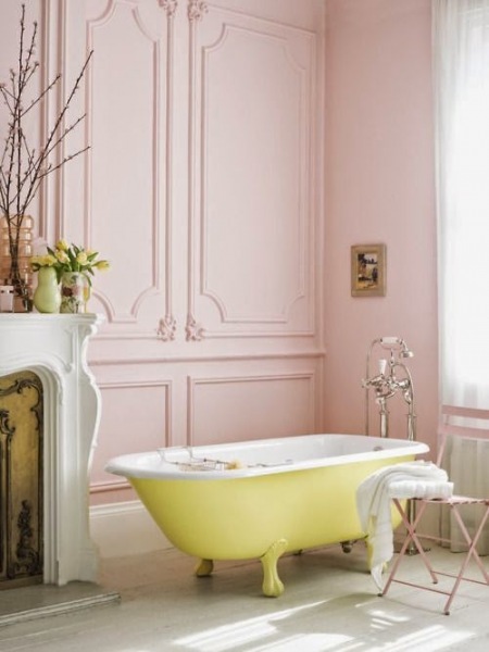 Różowe panele ścienne w stylu angielskim,biały portal kominkowy i cytrynowa wanna na nóżkach w stylowej łazience