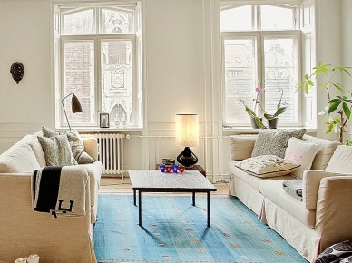 Nowoczesne obrazy,naturalne drewno,tkane dywany i proste witryny w skandynawskim salonie (25401)