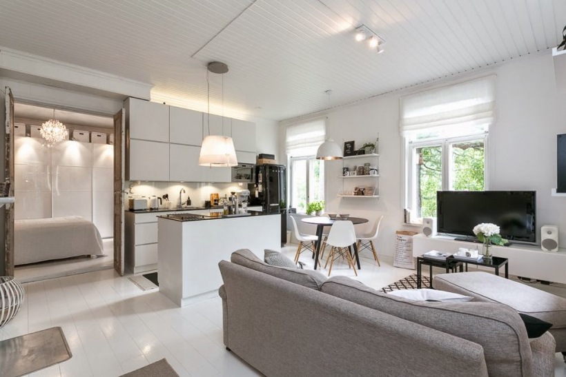 Salon połączony z kuchnią w otwartej zabudowie skandynawskiego domku