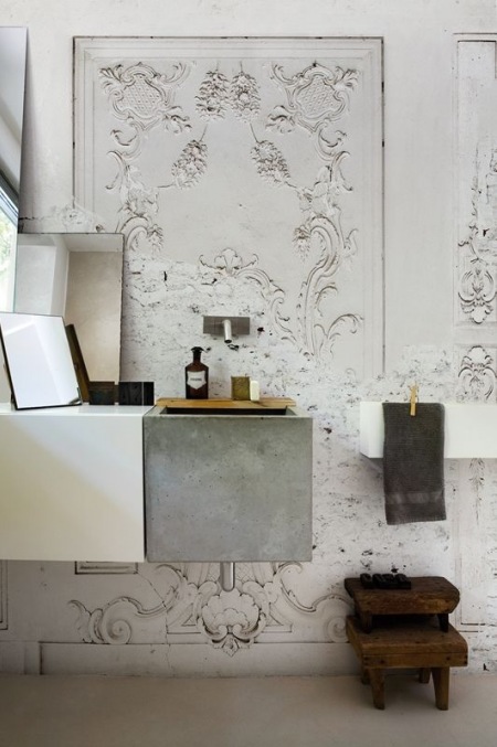 Stylowa fototapeta na scianie w łazience z kamenną umywalką,drewnianym stołkiem i lustrami vintage