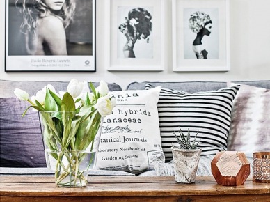 Dekoracja szarej sofy poduszkami w biało-czarne wzory i skandynawskie grafiki i fotografie na ścianie w salonie (28078)