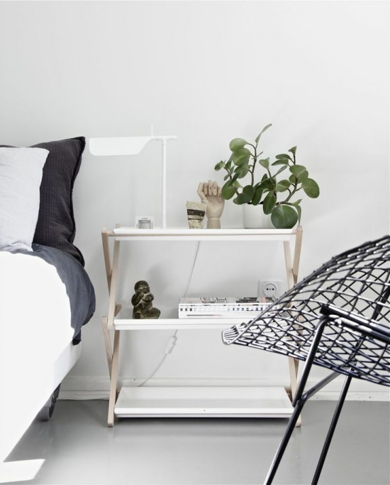 Srebrny  ażurowy fotel,drewniana szafka z białymi półkami tacami w aranżacji sypialni