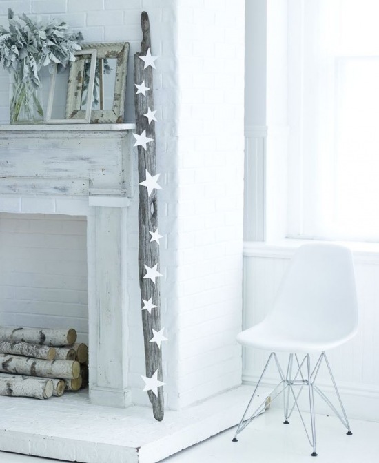 Bielony portal kominkowy z drewnem w światecznej minimalistycznej dekoracji z białymi gwiazdkami