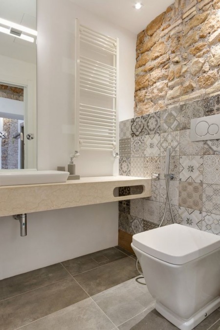 Ciepła łazienka z płytkami azulejos i cegłą na ścianie