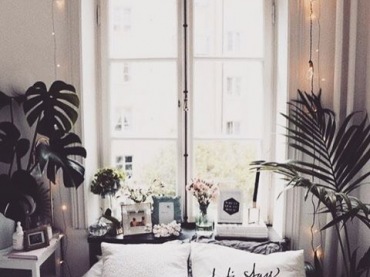 W bardzo małej sypialni wąskie łóżko ustawiono pod wysokim oknem. By dodać wnętrzu przytulności, na parapecie wystawiono sporo dekoracji, a na ścianie zawieszono romantyczną girlandę...