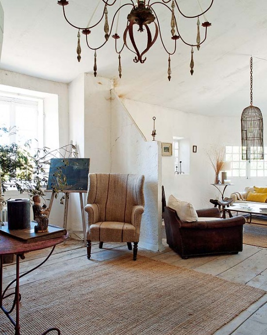 Sizalowy dywan, kuty stolik i druciany żyrandol  w aranżacji salonu