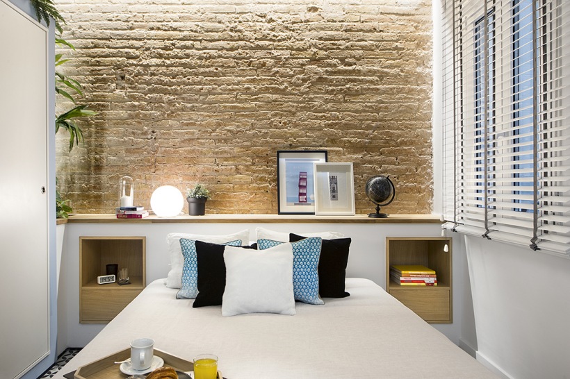 Piaskowe cegły w biało-błękitnej sypialni