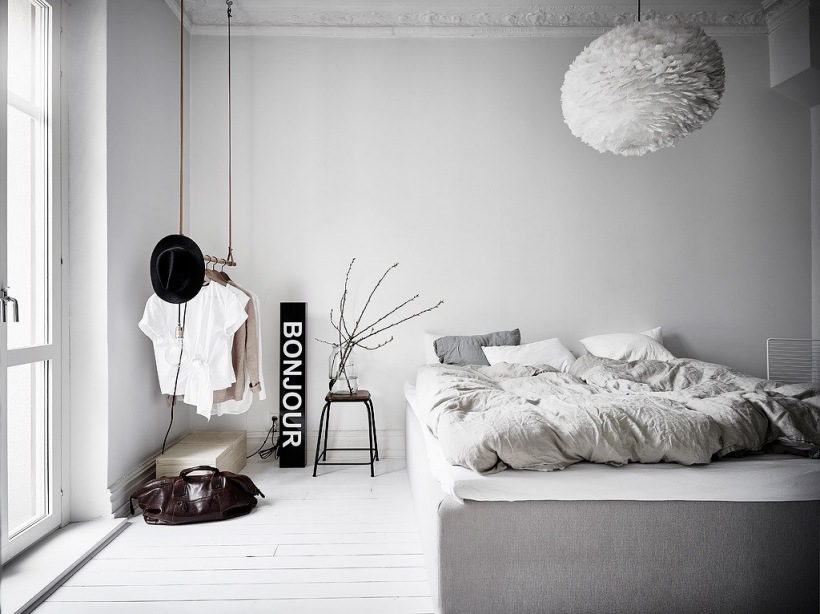 Przestronna sypialnia z szarym łóżkiem i białą podłogą