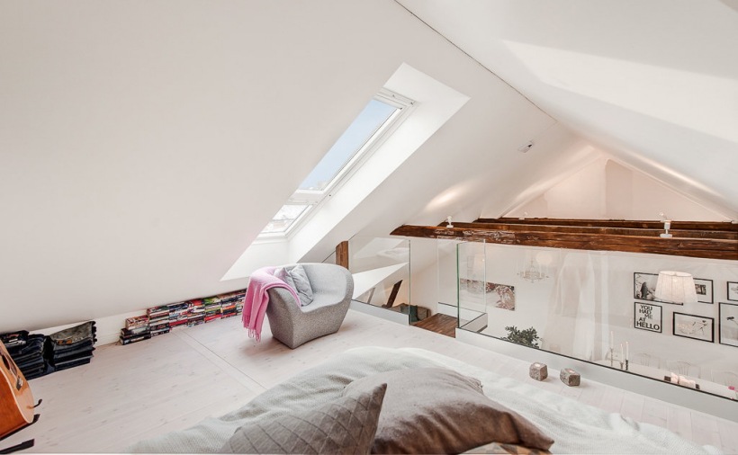Sypialnia na antresoli  ze szklaną balustradą i drewnianymi belkami