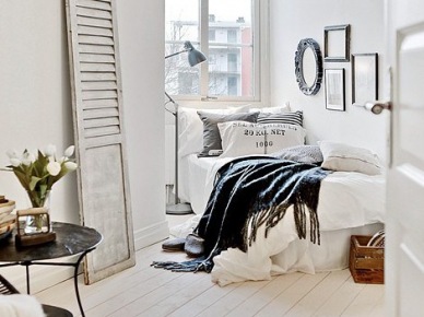 Drewniane bielone drzwi vintage jako dekoracja w sypialni z metalowym stolikiem tacą,skandynawski dywanikiem i ozdobnymi ramami w domowej galerii grafik na ścianie, (27705)