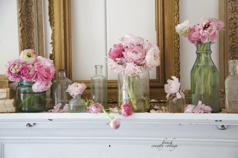 Różowe kwiaty w szklanych słoikach w aranzacji jadalni