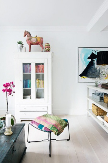 Kolorowe dodatki i pledy w aranżacji białego salonu w stylu skandynawskim