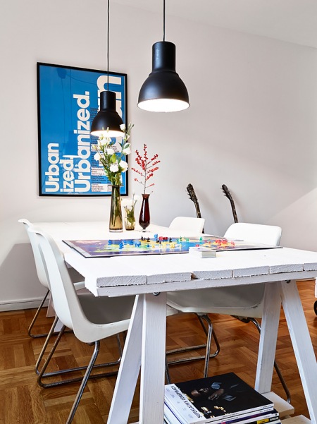 Stół z drewnianej palety, czarne lampy i białe krzesła w jadalni