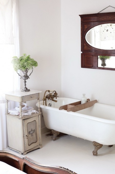 Aranżacja białej łazienki z wanną na łapkach i stylowymi francuskimi meblami