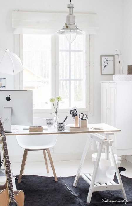Białe biurko skandynawskie na kozłach z drewnianym naturalnym blatem w domowym biurze