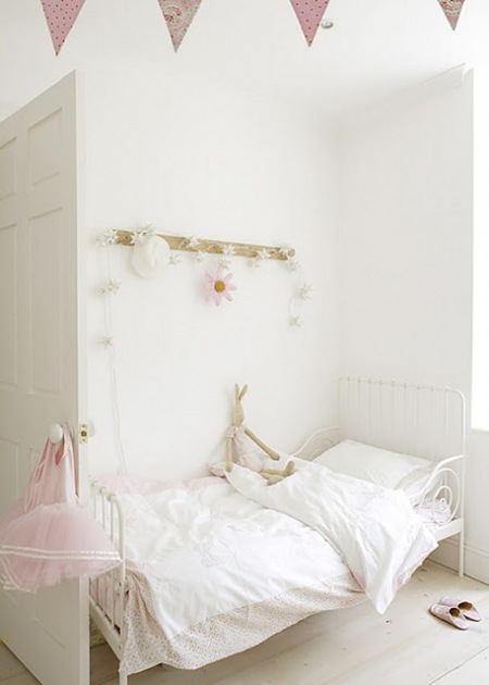 Białe kute łóżko w dziecięcym pokoju