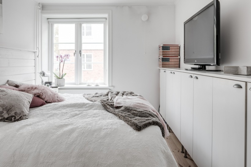 Aranżacja małej sypialni w białym kolorze z telewizorem