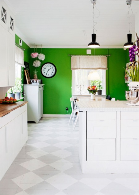 Biała kuchnia otwarta na zieloną jadalnię