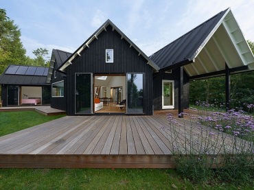 geometryczna bryła domu  Skandynawii zaciekawia i intryguje - to oryginalny projekt domu z ciemna elewacją i białym,...