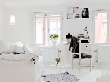 białe mieszkanie, w którym na jednej przestrzeni znalazły się kuchnia z sypialnią i salon z jadalnią - dobry pomysł na...
