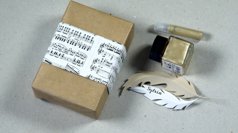 Prezenty i papierowe piórka jako etykiety w projekcie DIY