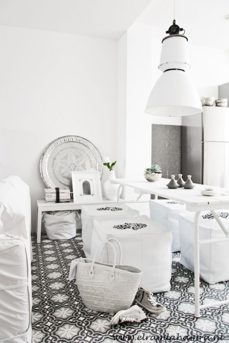 Marokańskie czarno-białe płytki na podłodze,srebrna taca matrokanska i duza biała lampa pendant nad stolem w jadalni