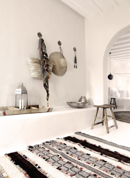 Monochromatyczne dywany tkane ręcznie w stylu marokańskim,srebrne latarenki i drewniane stołki i detale