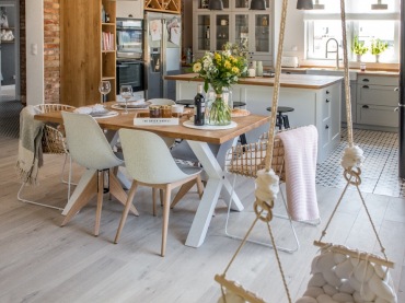 Kuchnia i jadalnia są połączone z salonem. Mają wiele elementów wspólnych, np. drewniane belki na suficie czy czerwone...