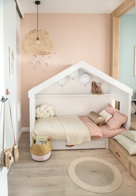 Pastelowy pokoik dziecięcy z drewnianą podłogą i łóżkiem-domkiem