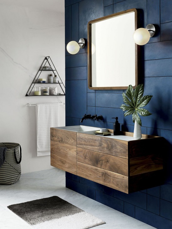 Granatowa ściana z drewnianą szafką w łazience