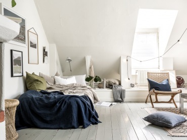 Łóżko przystawione jednym bokiem do ściany zaznacza strefę sypialni w pokoju dziennym. Pościel oraz poduszki na nim...