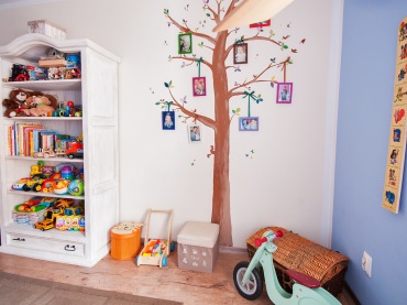 Piękna galeria ścienna w pokoju dziecięcym ozdabia wnętrze. W pokoiku znajduje się wiele zabawek i dodatków, zwłaszcza w mocno nasyconych odcieniach, które na tak jasnym tle również dekorują...