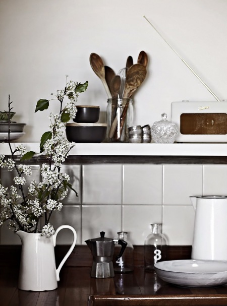 Drewniane, porcelanowe, metalowe  i  szklane detale w białej kuchni