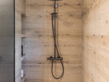 Akcenty drewna oraz czarne dodatki w łazience tworzą bardzo elegancki klimat. Prysznic jest duży i ma wbudowane półki...