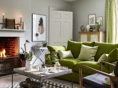 Zielona sofa i zielone dodatki w aranżacji salonu z kominkiem (55269)
