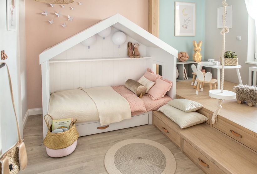 Białe łóżko-domek w pokoju dziecięcym z podestem
