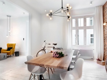 Drewniany stół i białe krzesła dobrze oddają klimat jadalni w stylu skandynawskim. Jasne tło, od podłogi, przez ściany,...