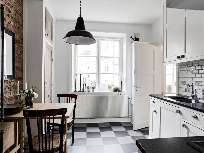 Ściana z cegły i posadzka w szachownicę w kuchni w stylu skandynawskim