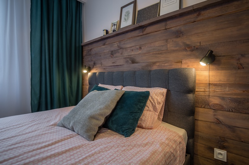 Sypialnia posiada jeden wyróżniający się element. Jest nim fragment ściany tuż za łóżkiem, który wyłożono drewnianymi...
