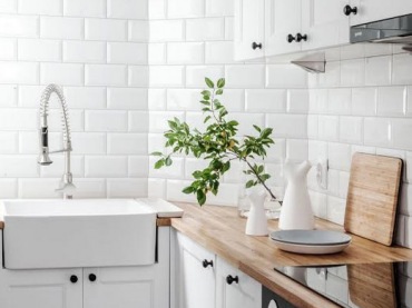 Białe kafle w kuchni wpisują się w skandynawski styl, w jakim urządzono wnętrze. W zestawieniu z drewnem podkreślają...