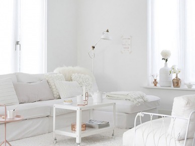 Sofa, stolik na kółkach, metalowy fotel i miedziane dodatki w aranżacji białego salonu (22881)