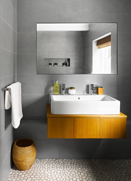 Łazienka w kolorze betonu z drewnianą podporą pod umywalkę