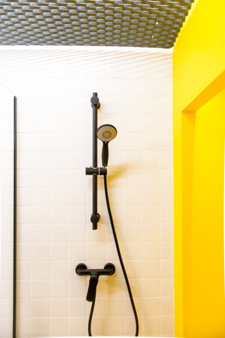 Żółta ściana w aranżacji minimalistycznej łazienki