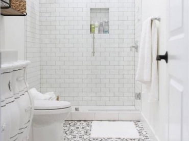 Biała łazienka ze wzorzystymi kafelkami na podłodze wygląda schludnie i subtelnie. Dzięki płytkom jej spokojny...