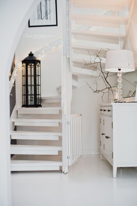 Jak zagospodarować mała przestrzeń pod białymi ażurowymi schodami,biała komoda pod schodami z białych desek,aranzacja przestrzeni pod ażurowymi schodami z białych desek,białe schody we wnętrzach,drewniane biale schody,białe ażurowe schod