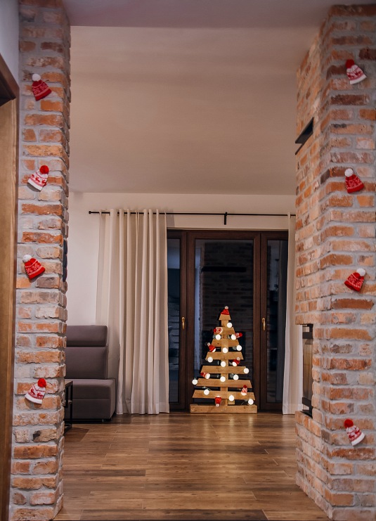 Niezwykle ciekawy pomysł na świąteczną choinkę, czyli drewniane drzewko przyozdobione lampkami. Czerwone drobne...