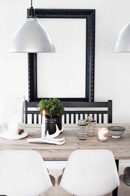 Czarne lustro, srebrna lampa i drewniany stół