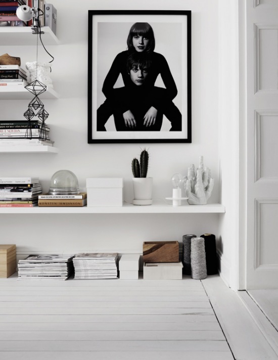 Piękna aranżacja z białymi półkami i czarno-białą fotografią na ścianie
